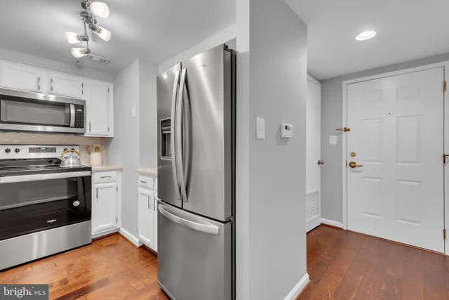 a kitchen with stainless steel appliances granite countertop a refrigerator and a stove top oven
