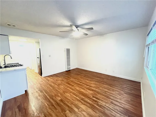 a kitchen with a stove white cabinets and sink