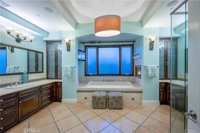 a spacious bathroom with a granite countertop sink mirror and a bathtub