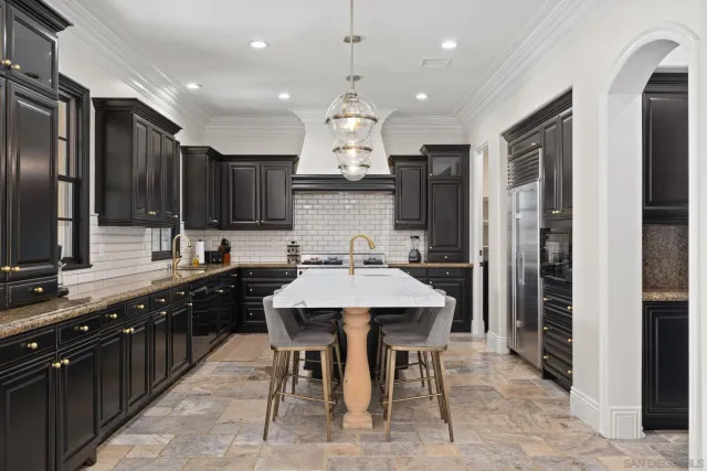 a large kitchen with kitchen island granite countertop a sink and a stove