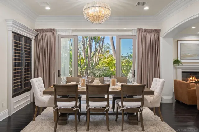 a dining room with furniture a chandelier and wooden floor