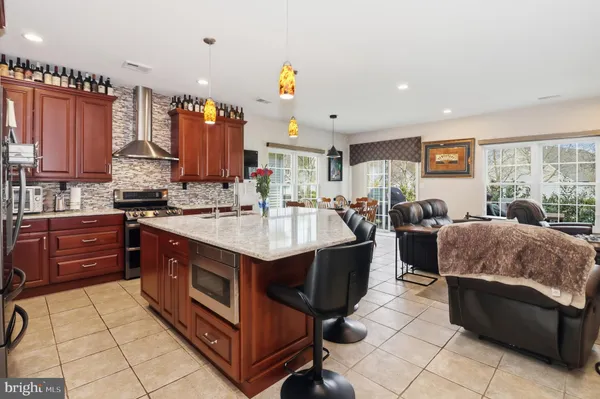 a kitchen with stainless steel appliances granite countertop a sink a stove and a dining table with white countertops