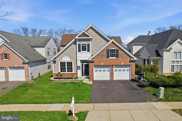 a front view of a house with a yard and potted plants