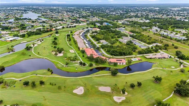 an aerial view of residential houses with outdoor space and parking