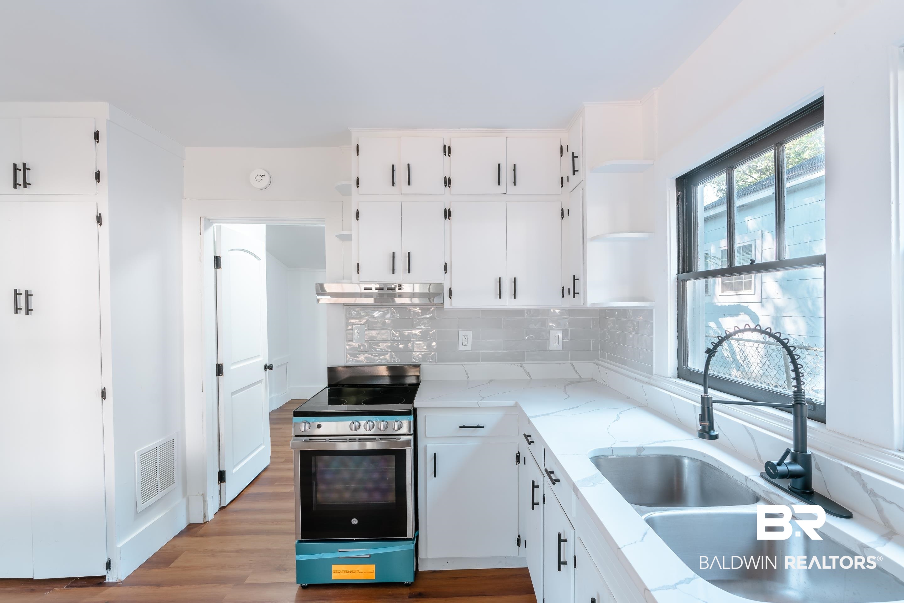 166 Crenshaw Street Mobile, AL 36606 - Photo 6 of 24 Kitchen featuring white cabinets, tasteful backsplash, stainless steel stove, light hardwood / wood-style floors, and sink