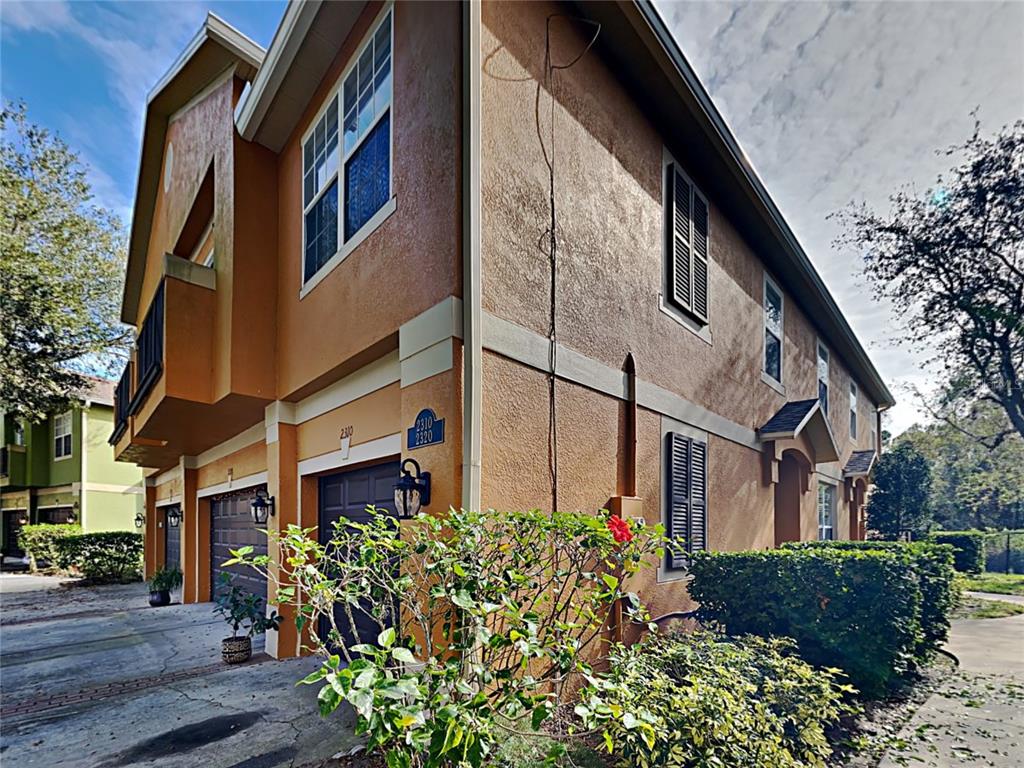 2310 Little Gem Loop Sanford, FL 32773 - Photo 1 of 1 a front view of a multi story residential apartment building with yard and retail shops