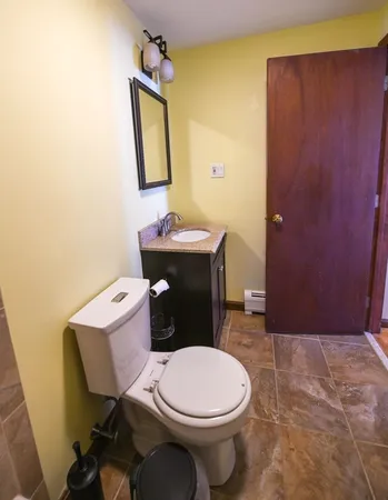 a bathroom with a toilet a sink and mirror