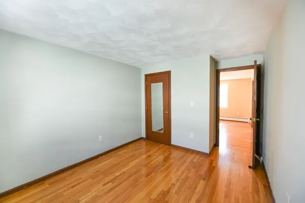 a view of a room with wooden floor and white walls