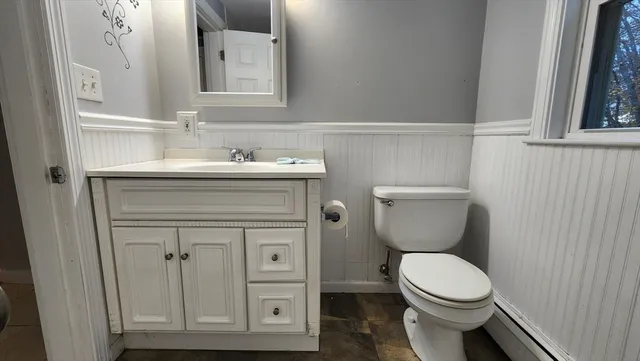 a bathroom with a toilet a sink and mirror