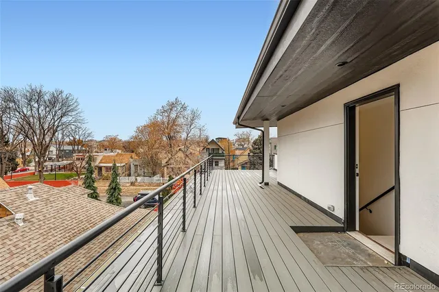 a view of a balcony with wooden floor and iron fence