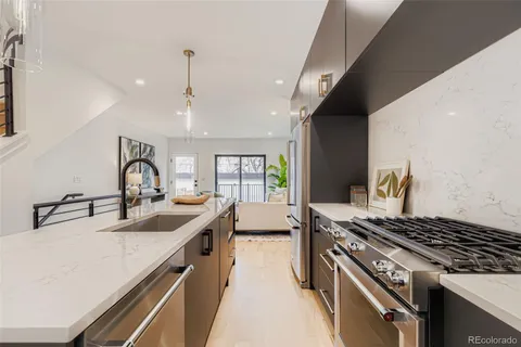 a kitchen with sink stove and refrigerator