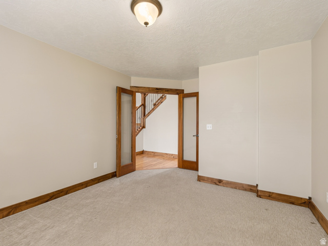 1279 West 1500th Street North Mapleton, UT 84664 - Photo 9 of 83 Carpeted room featuring wood-finish trim and double French doors with frosted glass panels