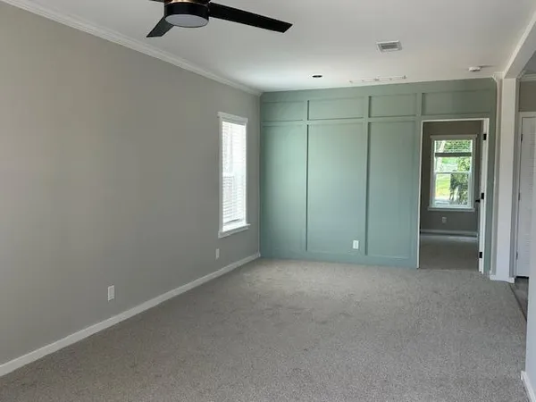 an empty room with windows and closet