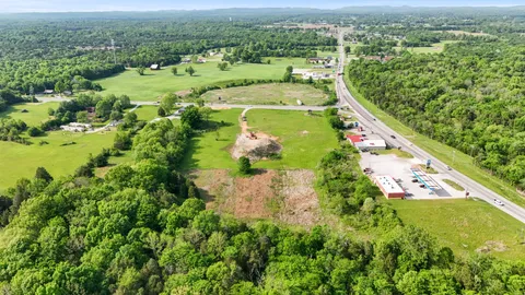 an aerial view of residential houses with outdoor space and trees all around