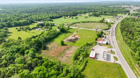 an aerial view of residential houses with outdoor space and trees