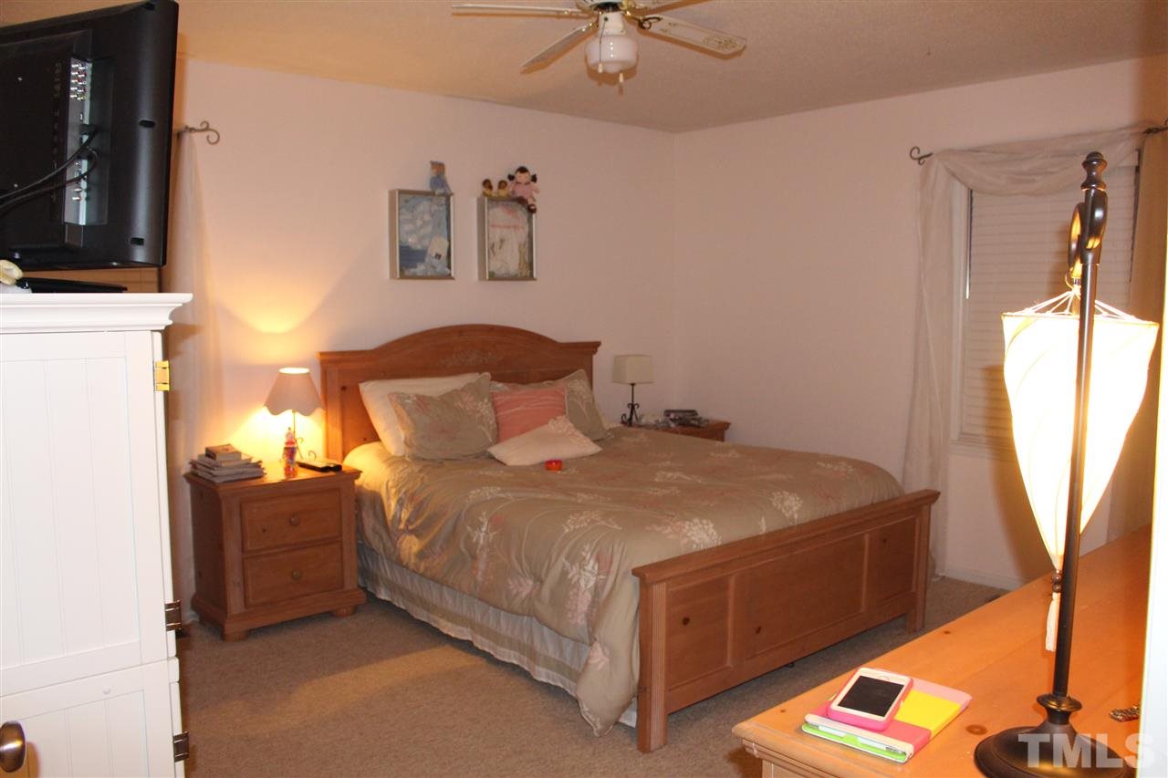 6735 Johnson Mill Road Durham, NC 27712 - Photo 13 of 18 a bedroom with a bed and a chandelier