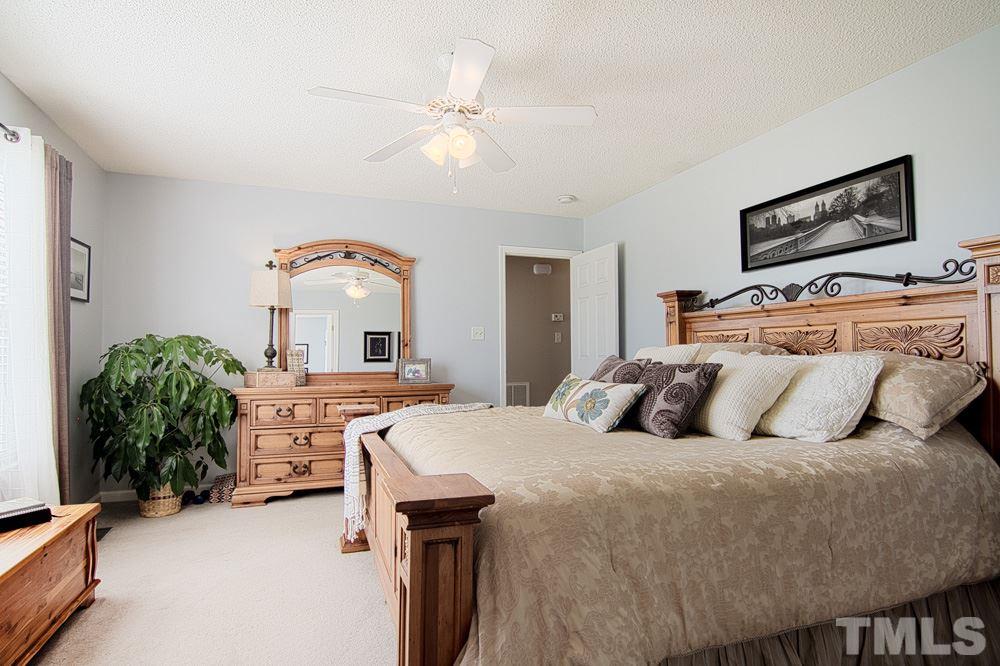 1409 Jenny Ridge Lane Willow Spring, NC 27592 - Photo 11 of 22 a bedroom with a bed and a chandelier