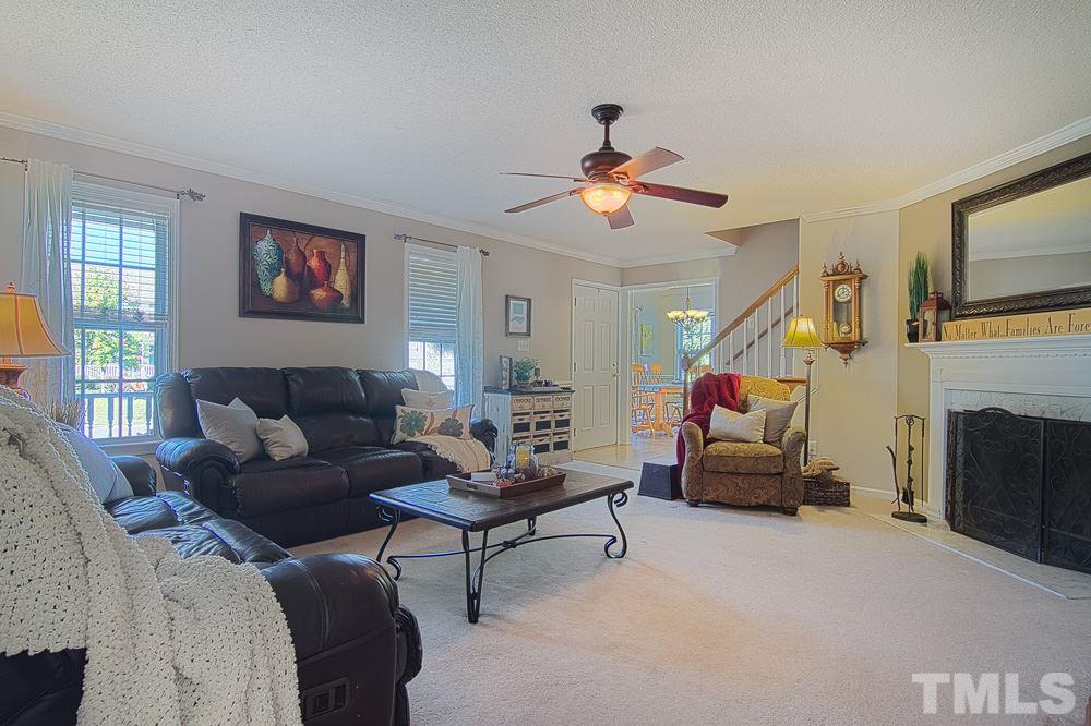 1409 Jenny Ridge Lane Willow Spring, NC 27592 - Photo 6 of 22 a living room with furniture a fireplace and a flat screen tv