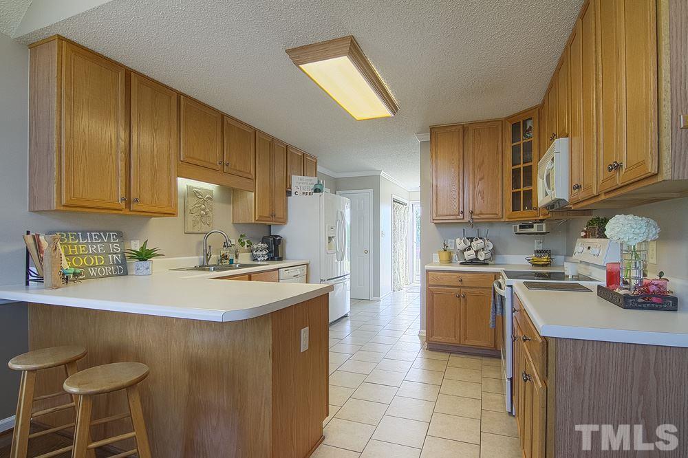 1409 Jenny Ridge Lane Willow Spring, NC 27592 - Photo 8 of 22 a kitchen with a sink a stove and chairs