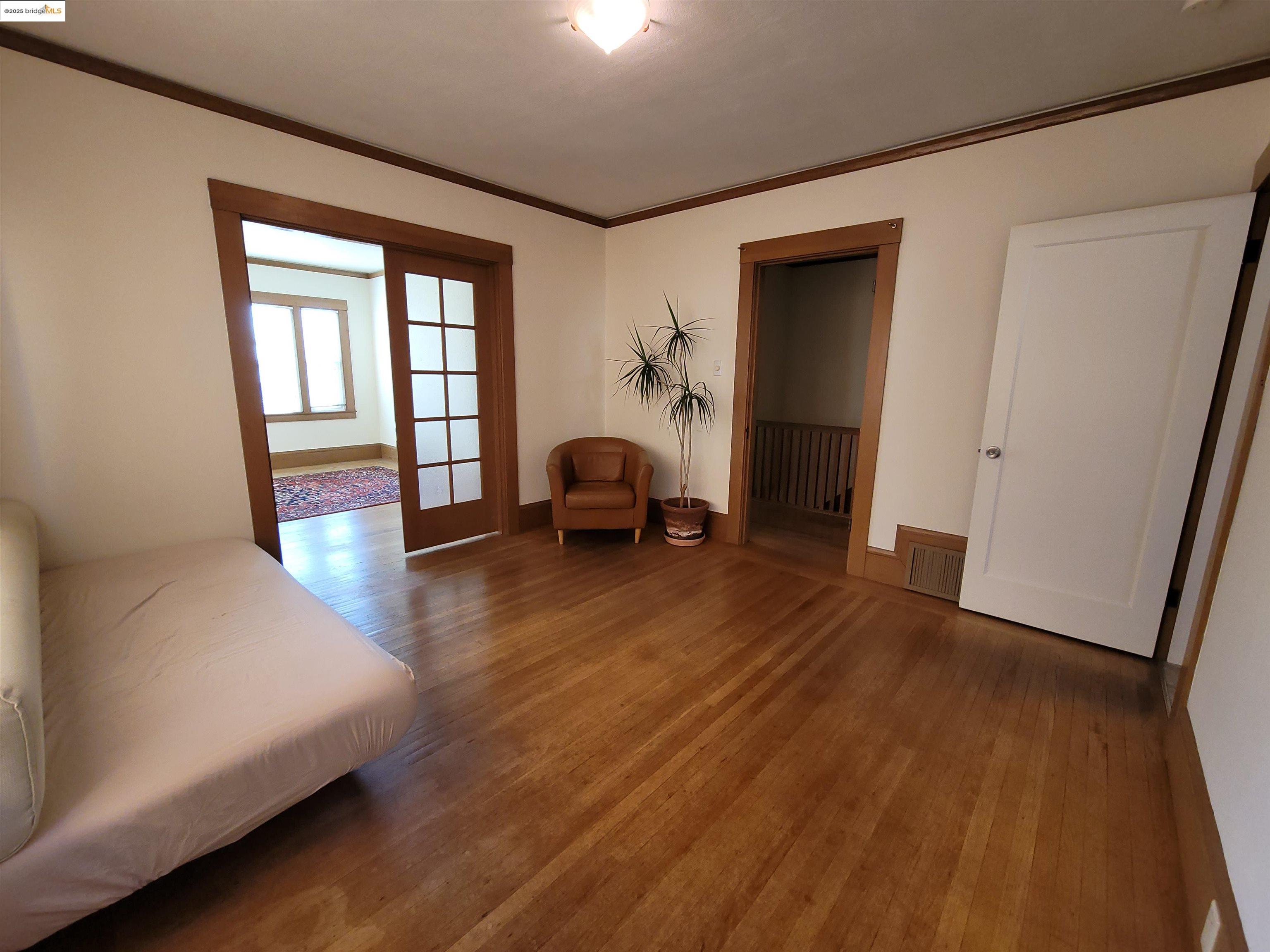 1901 Parker Street, Unit 3 Berkeley, CA 94704 - Photo 11 of 27 a bedroom with wooden floor and a large window