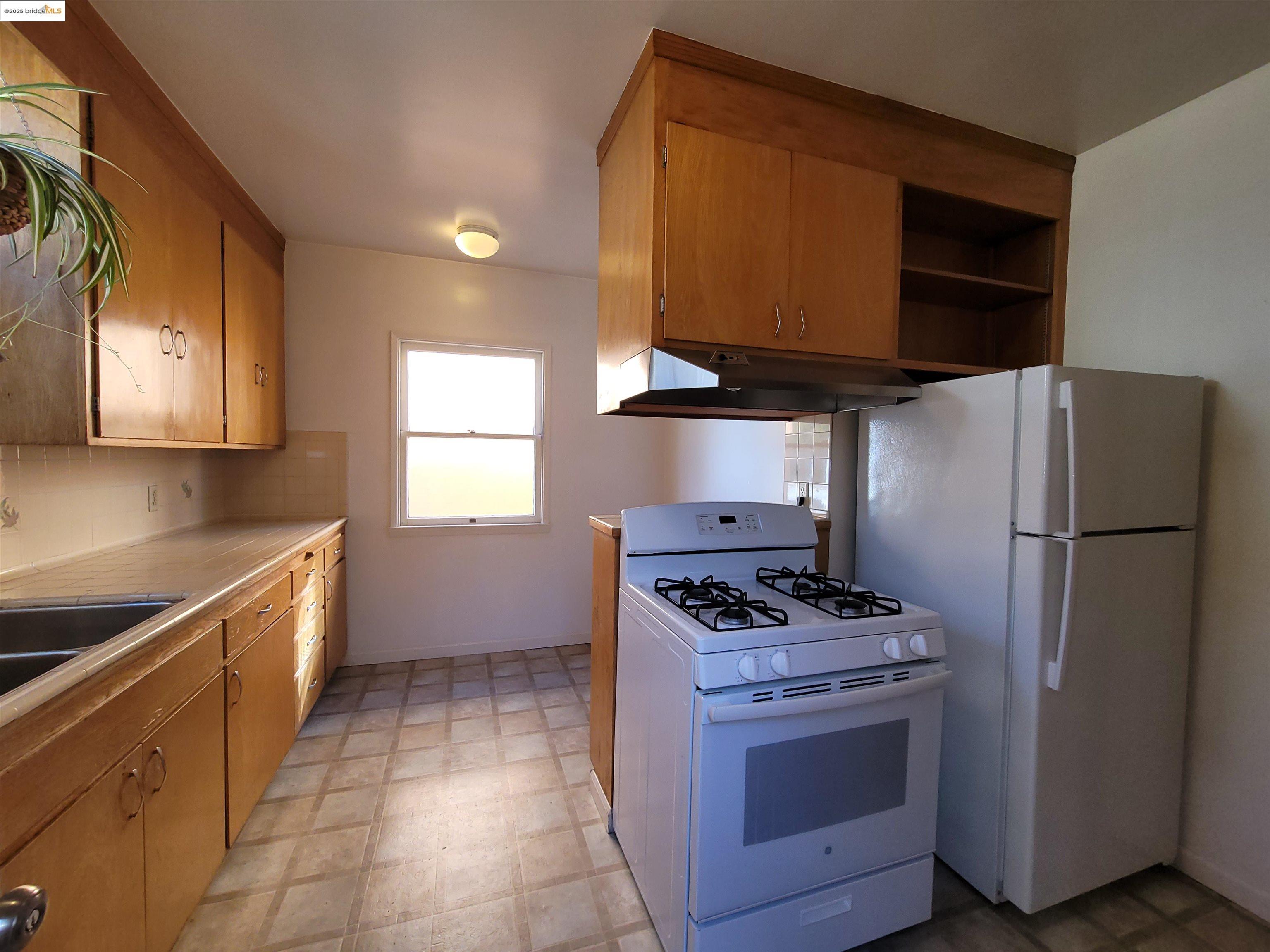 1901 Parker Street, Unit 3 Berkeley, CA 94704 - Photo 16 of 27 a kitchen with a stove refrigerator and microwave