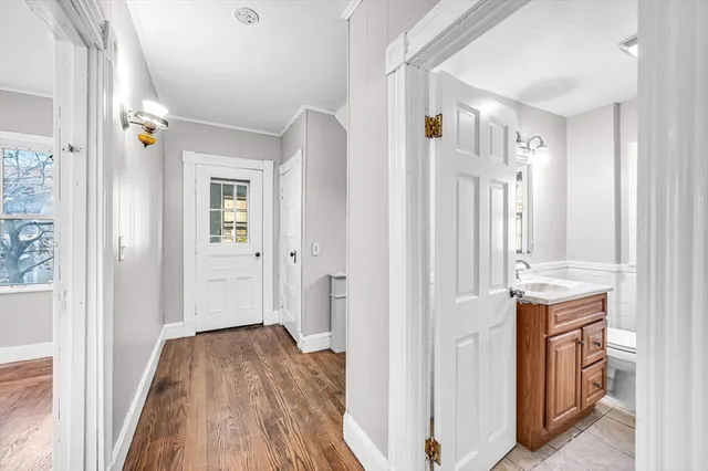 a view of a livingroom with wooden floor and a bathroom