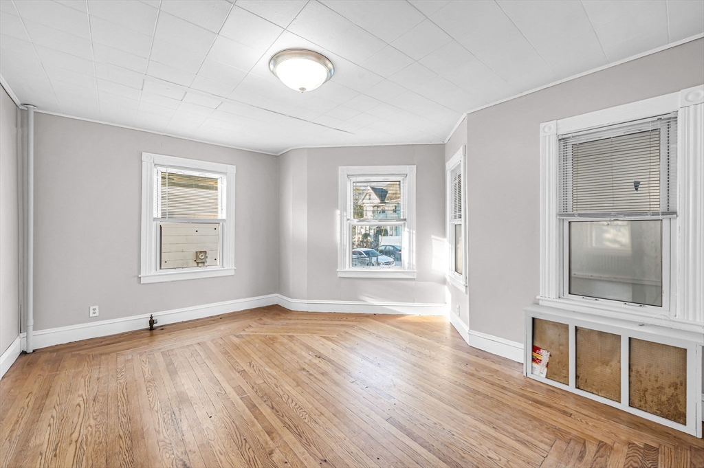 29 Wareham Street Springfield, MA 01108 - Photo 6 of 38 an empty room with wooden floor and windows