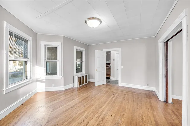 wooden floor in an empty room with a window