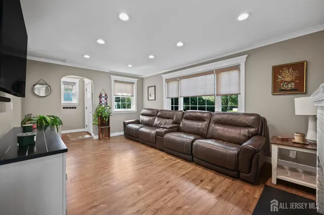 a kitchen with stainless steel appliances granite countertop a stove top oven a sink dishwasher a dining table and chairs with wooden floor