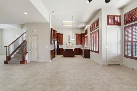 a view of a hallway with staircase and kitchen space
