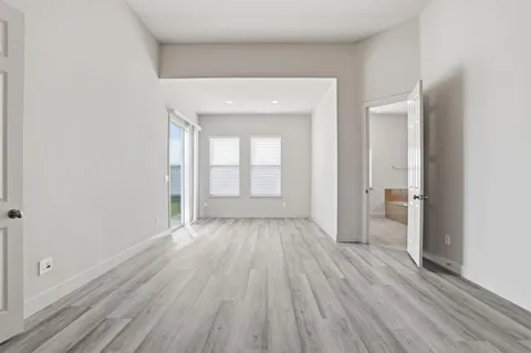 a view of a room with wooden floor a ceiling fan and closet area