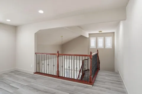 a view of a hallway with wooden floor and staircase