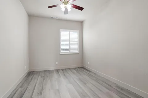 a view of a room with wooden floor and electronic appliances