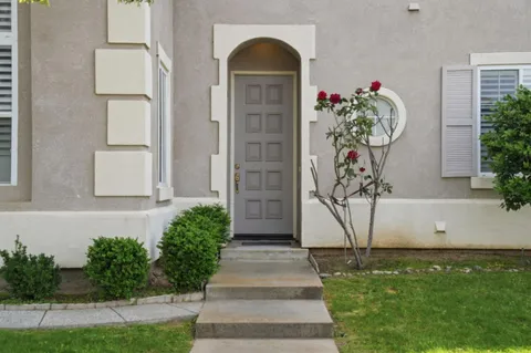 a front view of a house with plants