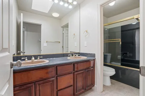 a utility room with stainless steel appliances granite countertop a refrigerator and a sink