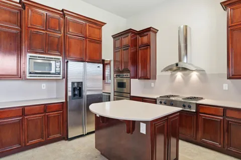a kitchen with stainless steel appliances granite countertop a sink a stove and refrigerator