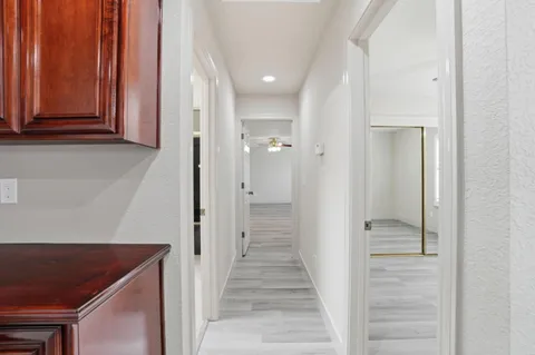 a view of a hallway with wooden floor and staircase
