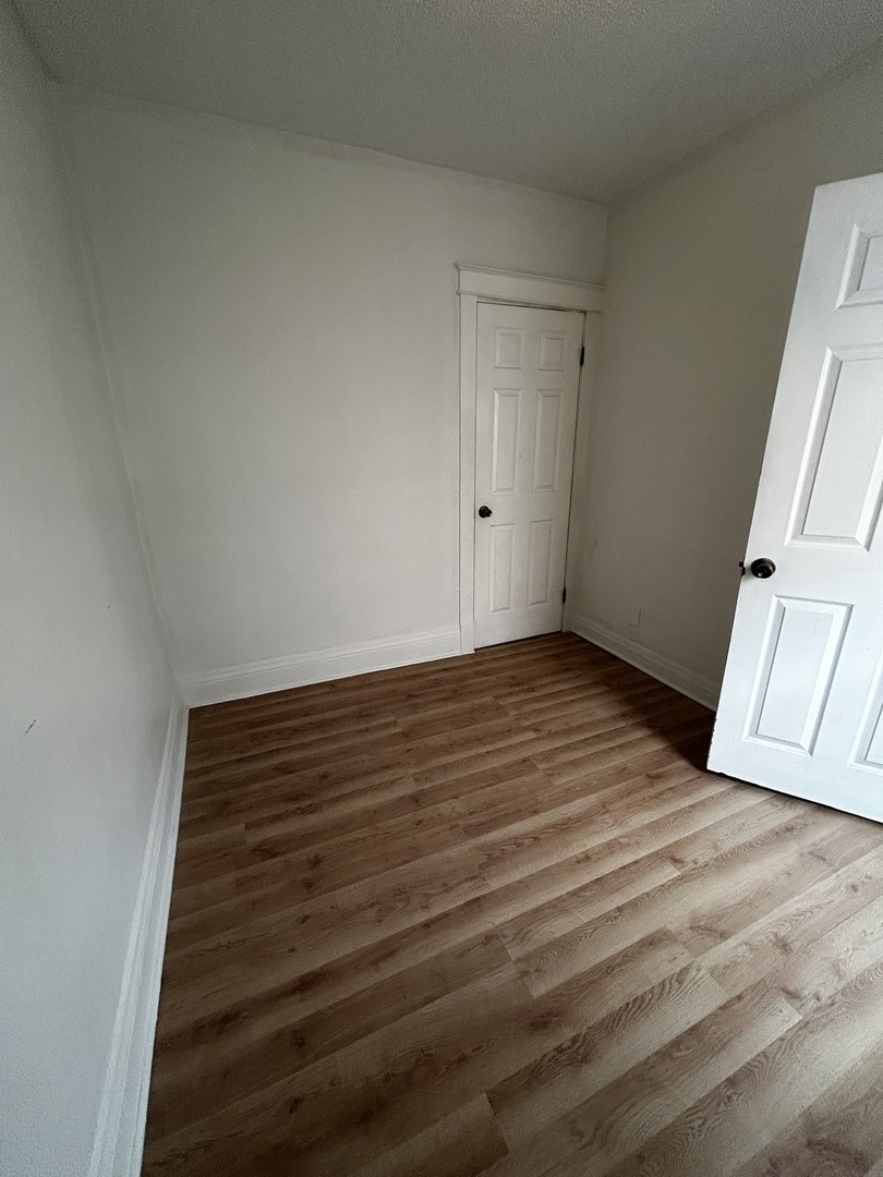1041 West 104th Place Chicago, IL 60643 - Photo 14 of 19 a view of an empty room with wooden floor and stairs