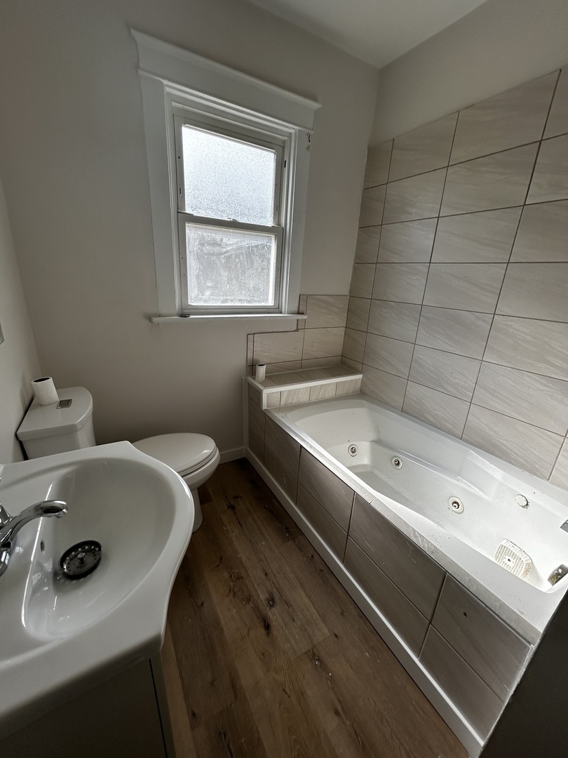 1041 West 104th Place Chicago, IL 60643 - Photo 16 of 19 a bathroom with a tub sink and mirror