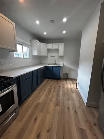 a large kitchen with wooden floors and stainless steel appliances