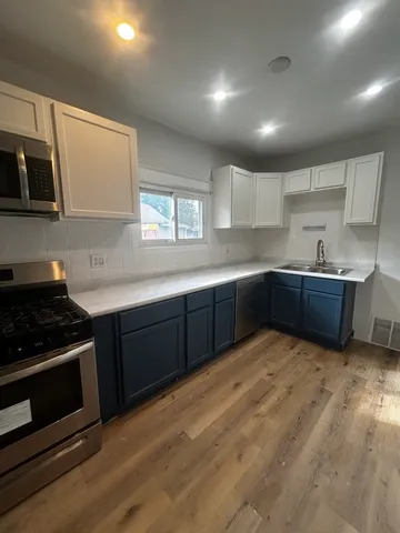 a kitchen with stainless steel appliances granite countertop a sink stove and microwave