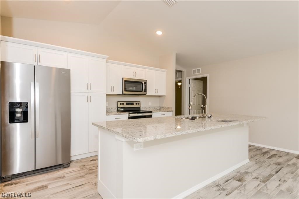 17397 Homewood Road Fort Myers, FL 33967 - Photo 6 of 14 a kitchen with stainless steel appliances a refrigerator stove microwave and sink