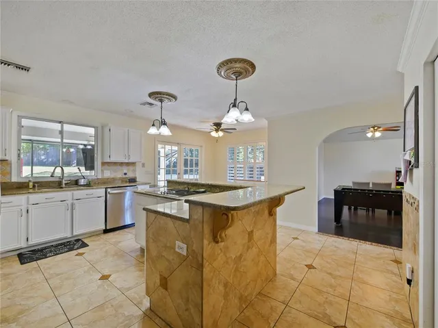 a kitchen with stainless steel appliances kitchen island granite countertop a sink and cabinets