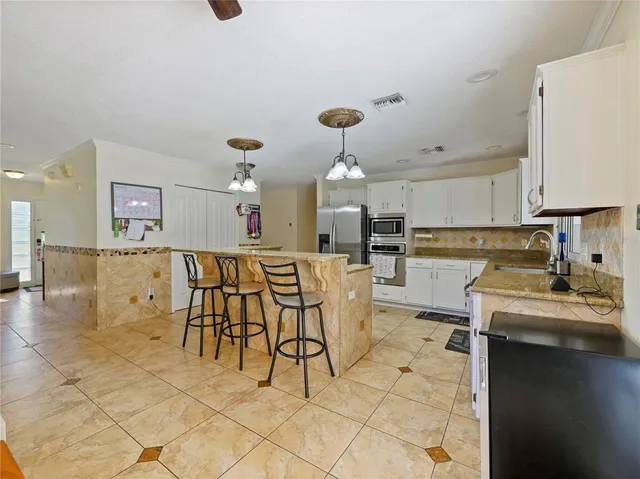 a kitchen with stainless steel appliances granite countertop a stove a sink dishwasher with a dining table and chair