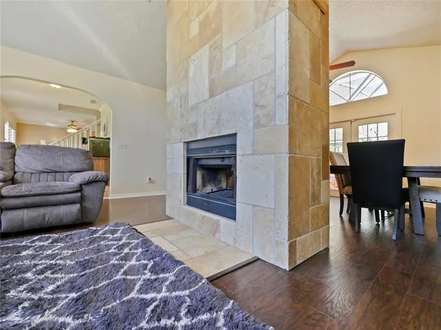 a living room with furniture kitchen view and a wooden floor