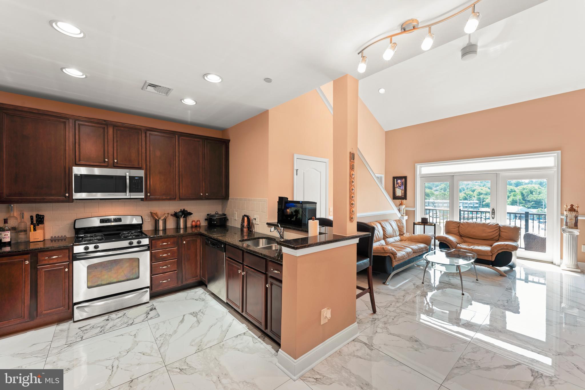 516 Carson Terrace Huntingdon Valley, PA 19006 - Photo 9 of 29 a kitchen with stainless steel appliances granite countertop a stove top oven a sink dishwasher a dining table and chairs with wooden floor
