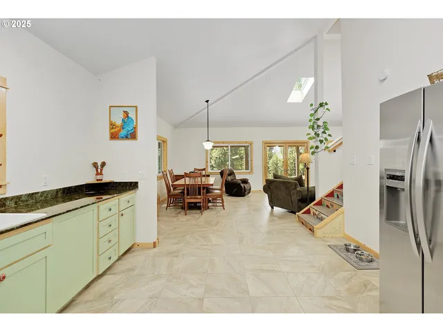 a living room with furniture a chandelier and a dining table