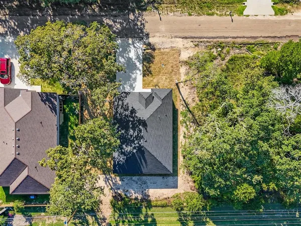 an aerial view of residential houses with outdoor space and trees