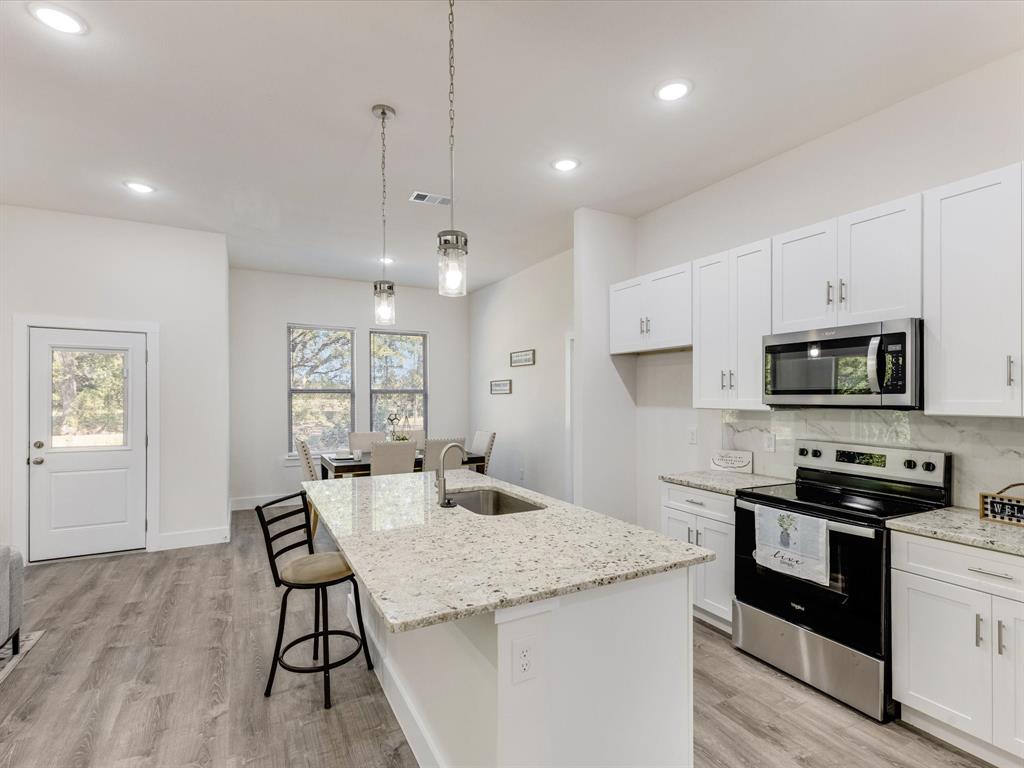 6123 Inca Drive Mabank, TX 75156 - Photo 8 of 31 a kitchen with granite countertop kitchen island white cabinets and stainless steel appliances