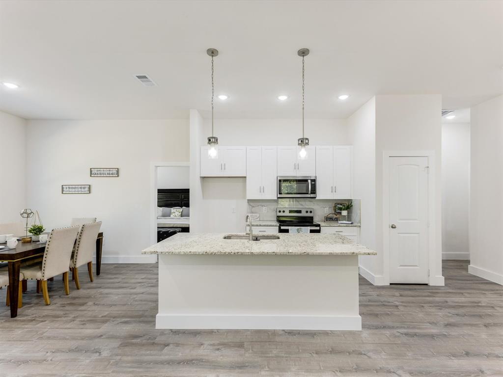 6123 Inca Drive Mabank, TX 75156 - Photo 10 of 31 a large white kitchen with kitchen island a table and chairs
